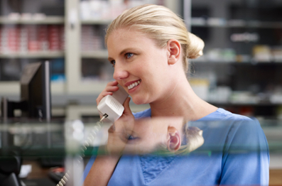 Blonde female smiling while on the phone in a medical office